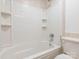 Bright bathroom with white tiled tub and shower features built-in shelving at 7416 Quail Ridge Dr, Charlotte, NC 28226