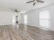 An empty room with wood-look flooring, ceiling fans, and natural light from two windows at 7416 Quail Ridge Dr, Charlotte, NC 28226