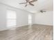Bright, empty room with wood-look flooring, ceiling fans, and natural light from the windows at 7416 Quail Ridge Dr, Charlotte, NC 28226