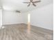 Spacious room with wood-look floors, two ceiling fans, and a doorway to another room at 7416 Quail Ridge Dr, Charlotte, NC 28226