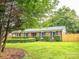 A charming brick home with shutters and a well-manicured lawn, framed by mature trees at 7416 Quail Ridge Dr, Charlotte, NC 28226