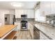 Modern kitchen with white cabinets, granite countertops, stainless steel appliances, and stylish backsplash at 7416 Quail Ridge Dr, Charlotte, NC 28226
