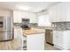 Modern kitchen with stainless steel appliances, white cabinetry, granite countertops, and a functional center island at 7416 Quail Ridge Dr, Charlotte, NC 28226