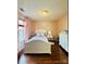 Charming bedroom with a white bed, hardwood floors, complemented by a bright window and dresser for a cozy retreat at 7918 Boars Head Ct, Charlotte, NC 28214