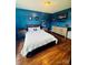 Comfortable bedroom with vibrant blue walls, hardwood floors, and a neatly arranged bed, creating a restful sanctuary at 7918 Boars Head Ct, Charlotte, NC 28214