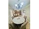 Dining area with a marble table, four upholstered chairs and views through to the kitchen at 7918 Boars Head Ct, Charlotte, NC 28214