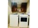 Functional laundry room with a washer, dryer, and overhead cabinets at 7918 Boars Head Ct, Charlotte, NC 28214