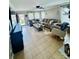 Bright living room featuring a comfortable sectional sofa, tile floors and ample natural light at 7918 Boars Head Ct, Charlotte, NC 28214