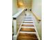 Climb the staircase with hardwood treads, white risers, and natural light, enhanced by neutral-toned walls and a wooden handrail at 7918 Boars Head Ct, Charlotte, NC 28214