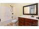 Bright bathroom features a tub/shower combo, cherry vanity, and a decorative framed mirror at 8993 Plank Rd, Norwood, NC 28128