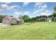 Attractive exterior shows a well-maintained home with a spacious yard and mature trees at 8993 Plank Rd, Norwood, NC 28128