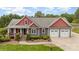 Charming two-story home with a manicured lawn, covered porch, and an attached two-car garage at 8993 Plank Rd, Norwood, NC 28128