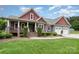 Charming gray two-story home with a manicured front lawn, covered porch, and attached two-car garage at 8993 Plank Rd, Norwood, NC 28128