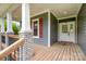 Inviting front porch with stone accents, wood flooring, and decorative columns, great for relaxation at 8993 Plank Rd, Norwood, NC 28128