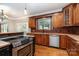 Well-equipped kitchen with a large window, wood cabinets, granite counters, and stainless steel appliances at 8993 Plank Rd, Norwood, NC 28128