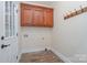 Well-lit laundry room includes overhead cabinets, and convenient access to an exterior door at 8993 Plank Rd, Norwood, NC 28128