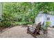Inviting backyard featuring a fire pit area with Adirondack chairs and a storage shed at 9011 Brad Ct, Matthews, NC 28104
