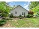 A spacious yard with a garden, stone pathway, and the home's vinyl siding at 9011 Brad Ct, Matthews, NC 28104