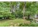 Serene backyard featuring lush greenery, a charming pergola, and stone paver accents at 9011 Brad Ct, Matthews, NC 28104