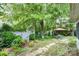 Lush backyard with a patio dining set under a large tree, showcasing a peaceful retreat at 9011 Brad Ct, Matthews, NC 28104