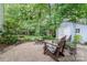 Inviting backyard featuring a fire pit area with Adirondack chairs and a storage shed at 9011 Brad Ct, Matthews, NC 28104