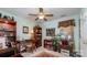 Cozy bedroom or office with a ceiling fan, desk, bookshelves and neutral colored walls at 9011 Brad Ct, Matthews, NC 28104