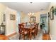 Dining room featuring hardwood floors, an elegant chandelier, and views into the living room and sunroom at 9011 Brad Ct, Matthews, NC 28104