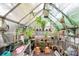A well-lit greenhouse filled with plants and gardening supplies provides a serene space at 9011 Brad Ct, Matthews, NC 28104