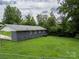 Backyard view of home with brick exterior, grassy lawn, and surrounding trees at 102 Central Ave, Bessemer City, NC 28016