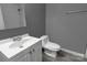 Neutral bathroom features a modern sink, toilet, and gray walls at 102 Central Ave, Bessemer City, NC 28016