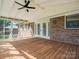 Covered back porch with a wooden floor, brick wall, ceiling fan, and screened in walls at 10728 Forest Dr, Matthews, NC 28105