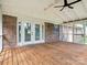 Covered back porch with a wooden floor, brick wall, ceiling fan, and screened in walls at 10728 Forest Dr, Matthews, NC 28105