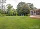 Spacious green backyard with a wooden deck and screened in back porch at 10728 Forest Dr, Matthews, NC 28105