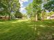 Home exterior with a spacious, green backyard with shed and a screened in back porch at 10728 Forest Dr, Matthews, NC 28105