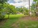 Home exterior with a spacious, green backyard with shed and a screened in back porch at 10728 Forest Dr, Matthews, NC 28105