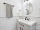 Modern bathroom featuring a sleek vanity, round mirror, and elegant marble-style tiling at 10728 Forest Dr, Matthews, NC 28105