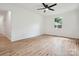Bright bedroom with light wood floors, neutral walls, window, and ceiling fan at 10728 Forest Dr, Matthews, NC 28105