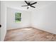 Empty bedroom with a ceiling fan and light wood floors at 10728 Forest Dr, Matthews, NC 28105