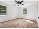 Well-lit bedroom with hardwood floors, two windows, and a ceiling fan at 10728 Forest Dr, Matthews, NC 28105