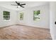 A bright bedroom with three windows, light wood floors, and neutral walls at 10728 Forest Dr, Matthews, NC 28105