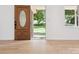 Bright entryway with hardwood floors, decorative front door, and a glimpse of the backyard at 10728 Forest Dr, Matthews, NC 28105