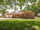Attractive single-story brick home featuring an attached garage, rocking chairs, and a well-maintained lawn at 10728 Forest Dr, Matthews, NC 28105
