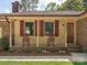 Inviting front porch featuring rocking chairs, brick accents, and a decorative front door at 10728 Forest Dr, Matthews, NC 28105