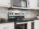 Close-up of stainless steel oven and microwave, granite counters and shaker cabinets at 10728 Forest Dr, Matthews, NC 28105