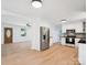 Open-concept kitchen featuring stainless steel appliances, white cabinetry, and hardwood floors at 10728 Forest Dr, Matthews, NC 28105