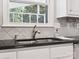 Close-up of a kitchen sink featuring granite counters, white cabinets, and outdoor view at 10728 Forest Dr, Matthews, NC 28105