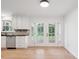 Bright kitchen featuring white cabinets, stainless appliances, and backyard views at 10728 Forest Dr, Matthews, NC 28105