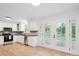 Well-lit kitchen featuring white cabinets, stainless appliances, and double doors to the yard at 10728 Forest Dr, Matthews, NC 28105