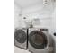 Modern laundry room with front load washer and dryer and white wire shelving for storage at 10728 Forest Dr, Matthews, NC 28105