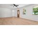 Large, bright living room featuring hardwood floors, neutral paint, and a decorative front door at 10728 Forest Dr, Matthews, NC 28105